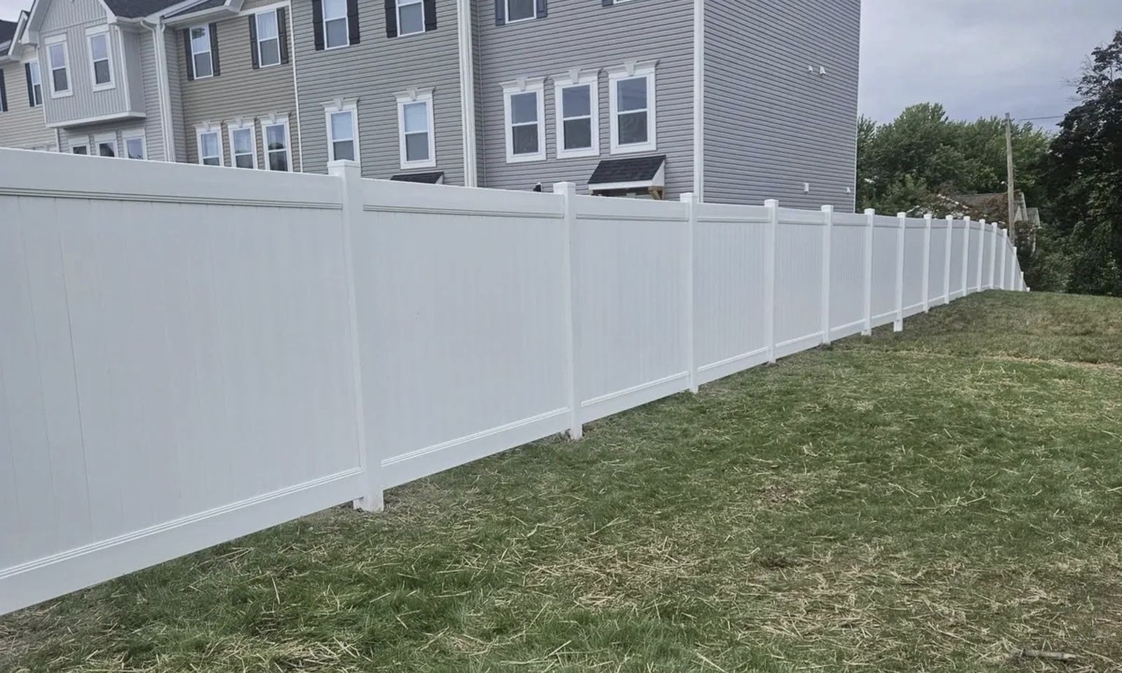 new-white-fence-with-houses-in-background-and-grass-va