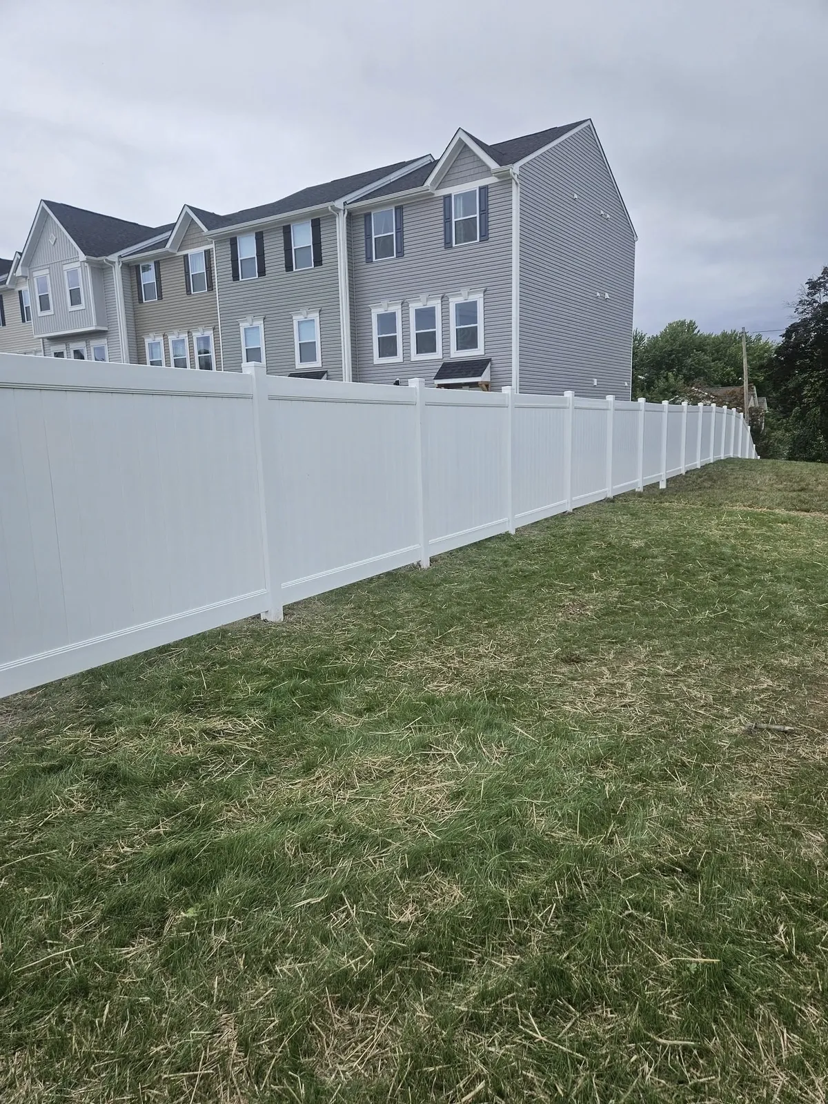 new-white-fence-with-houses-in-background-and-grass-va