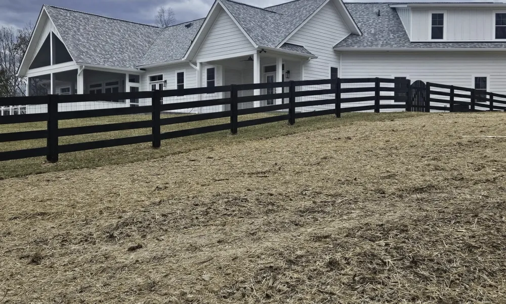 new-house-with-aluminum-fence-and-grassy-hillbackground